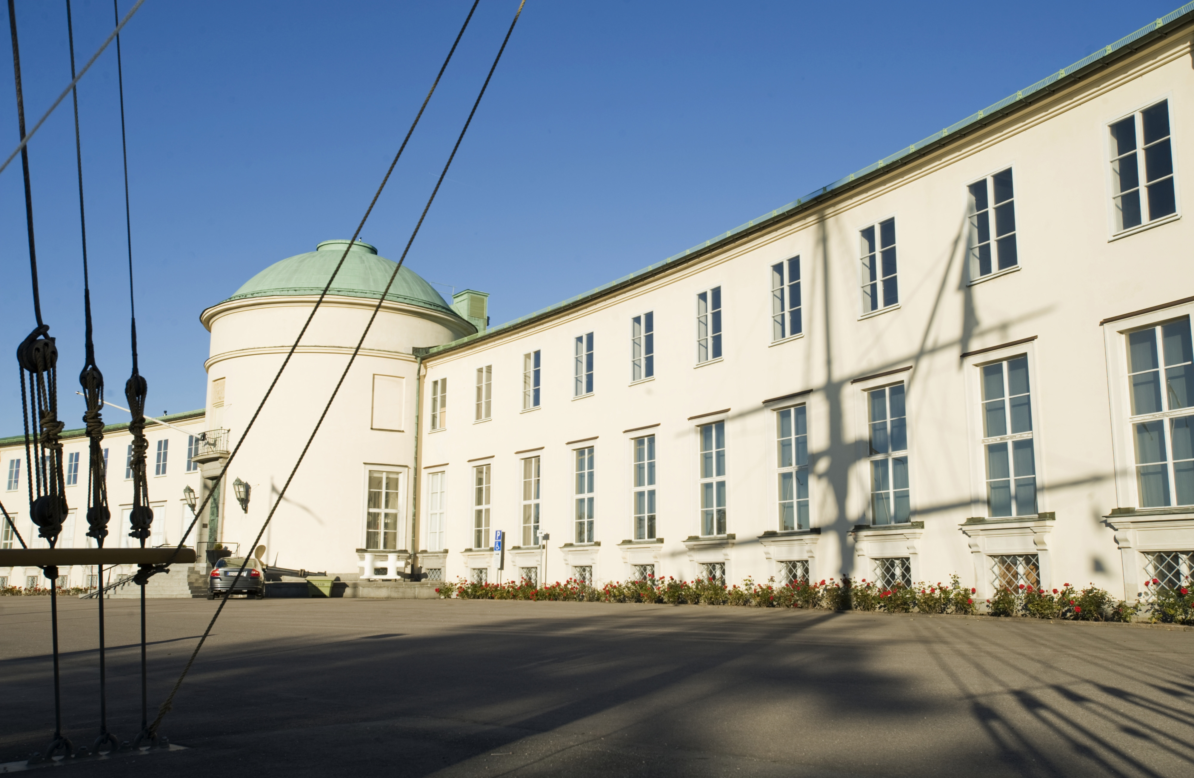 Sjöhistoriskas museums vita byggnad framför en klarblå himmel.