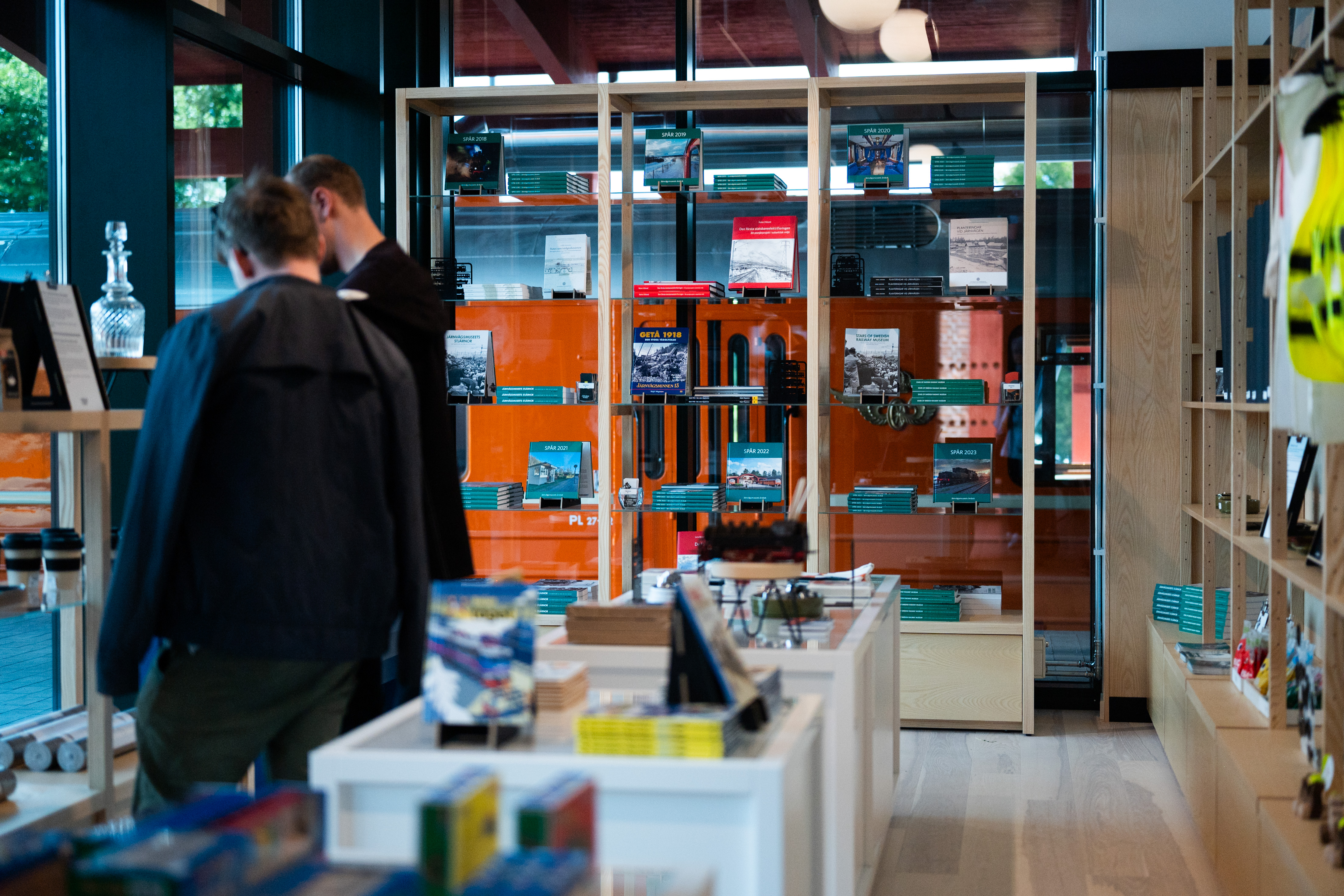 Två manliga kunder tittar på föremål i en butik.