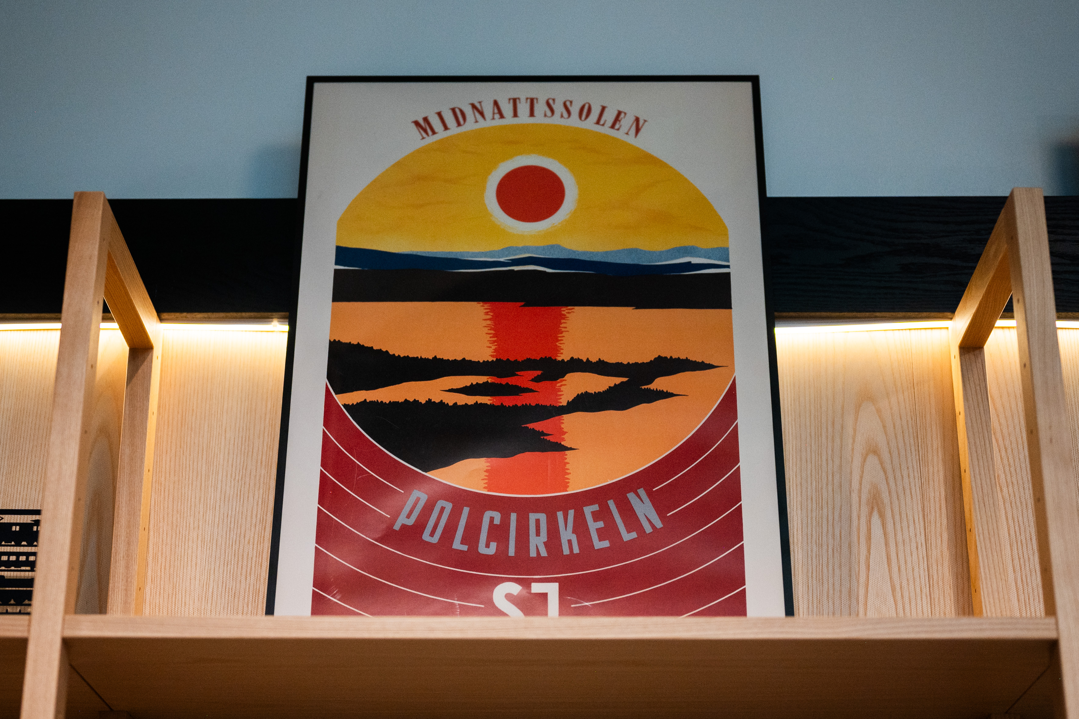Tågaffisch med solnedgångtåendes på en hylla.