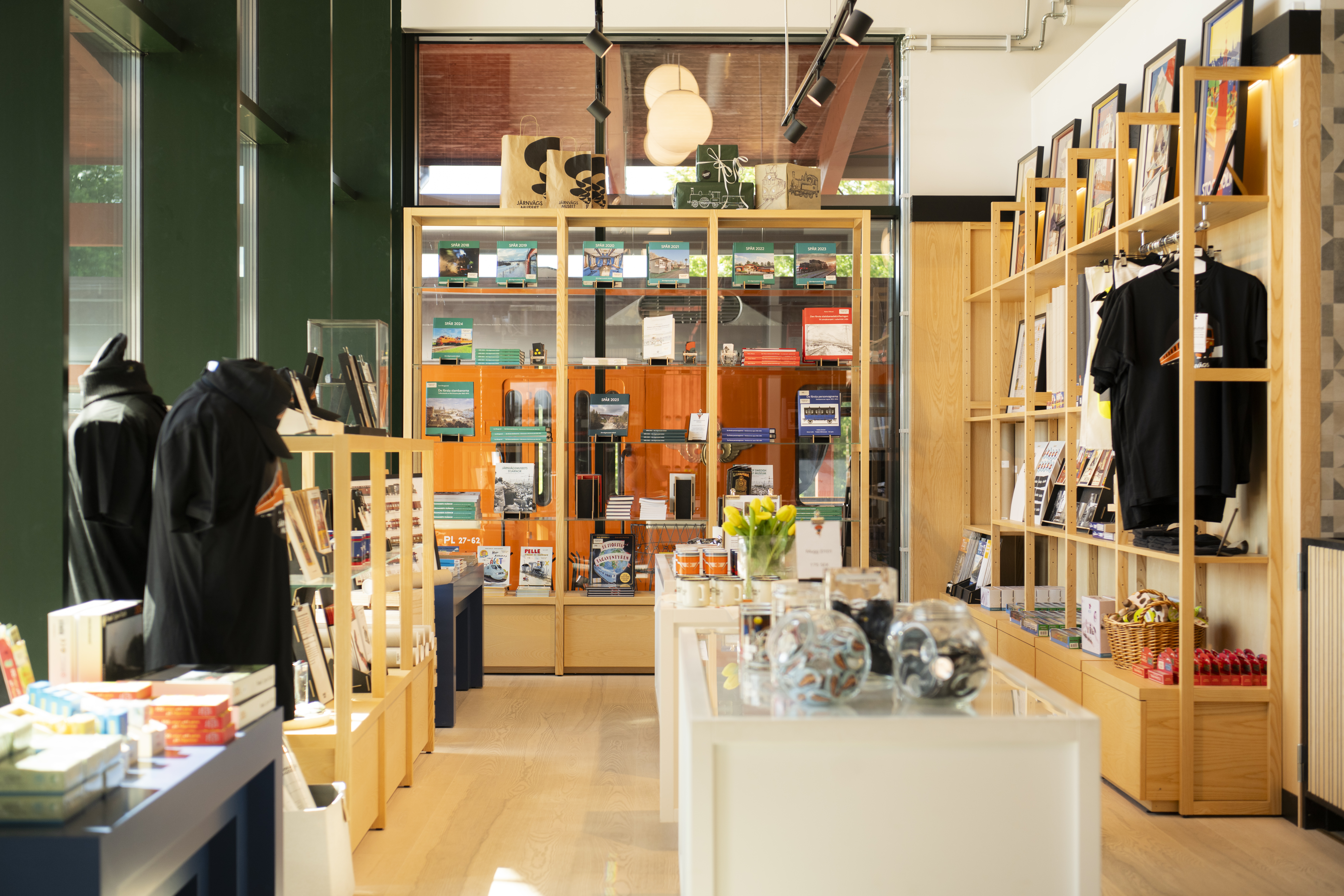 Vy över hyllor fyllda med böcker, muggar och andra souvenirer i en museishop.