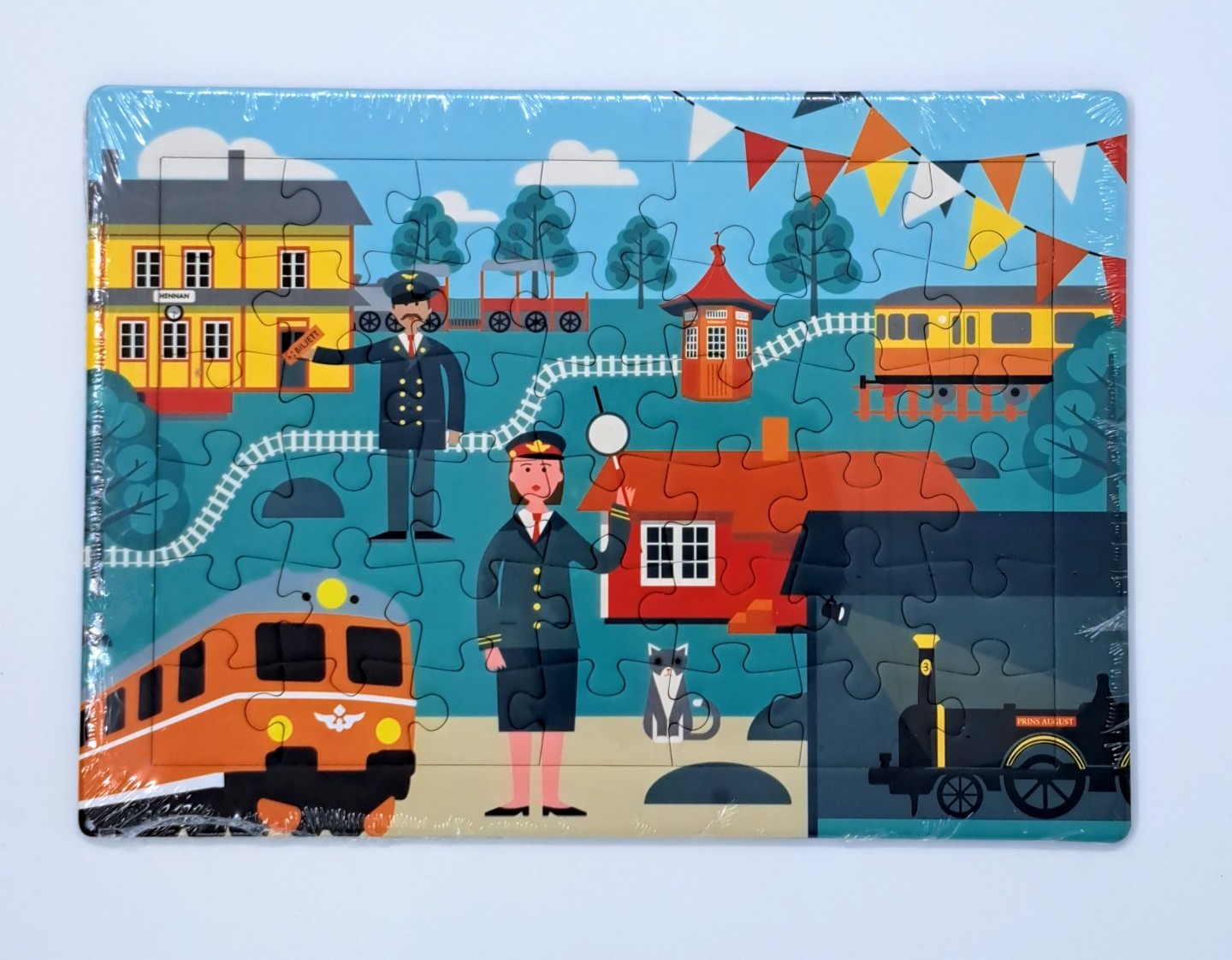 Ett pussel med motiv av tåg, lok, stationshus och tågpersonal.