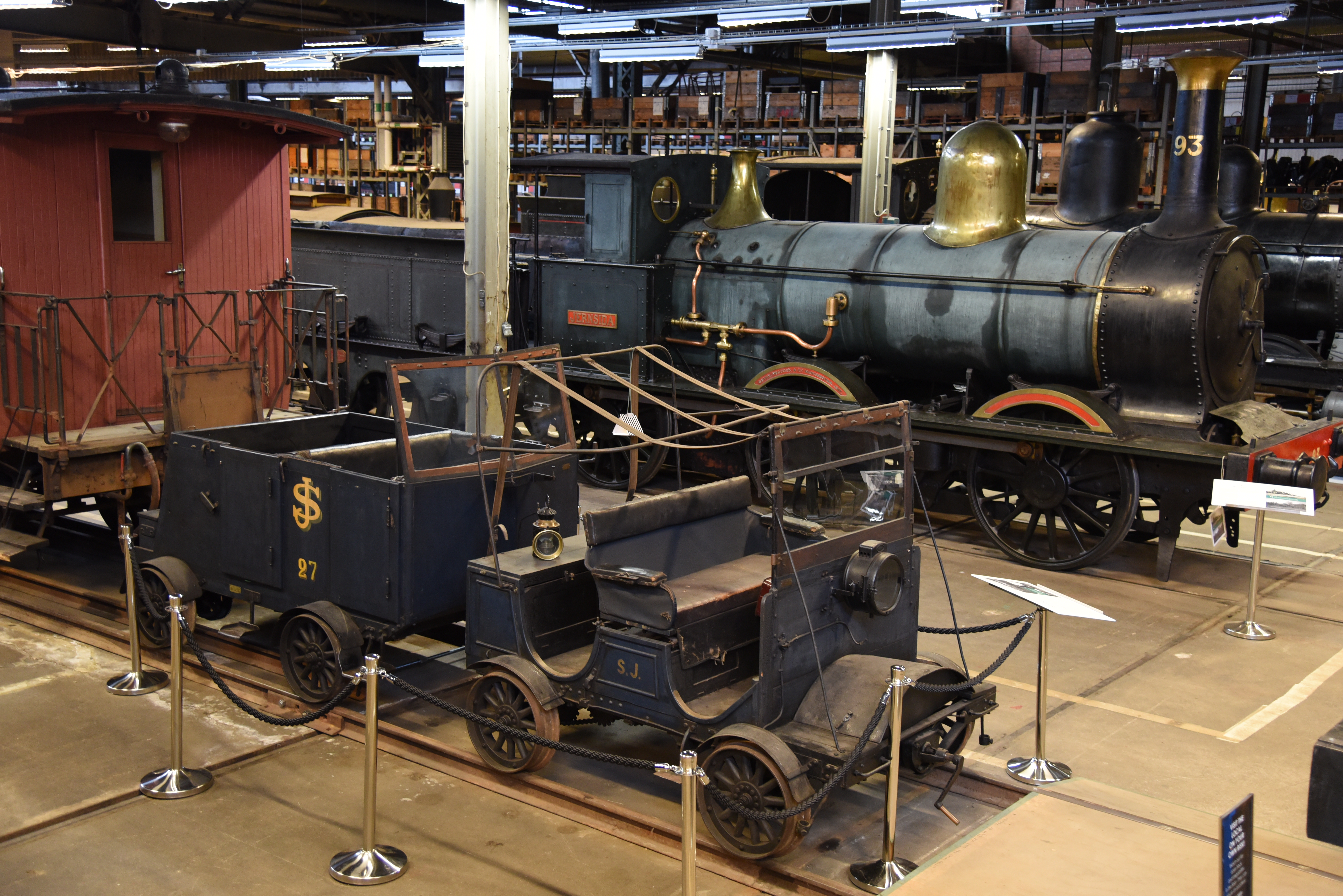 Flera gamla tågvagnar står på en rad.