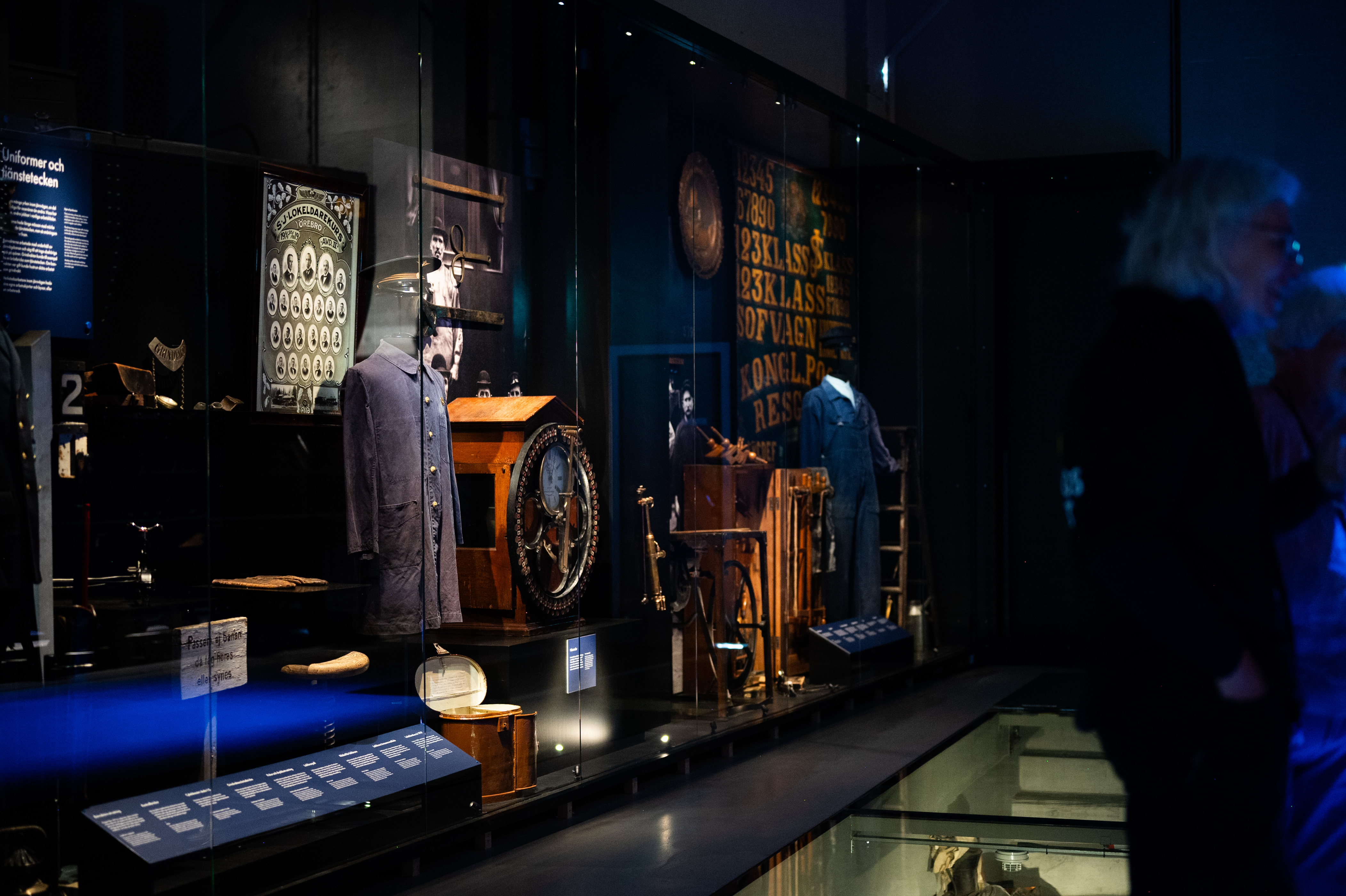 Flera föremål relaterat till järnväg syns i en glasmonter, bland annat syns arbetskläder och en klocka 