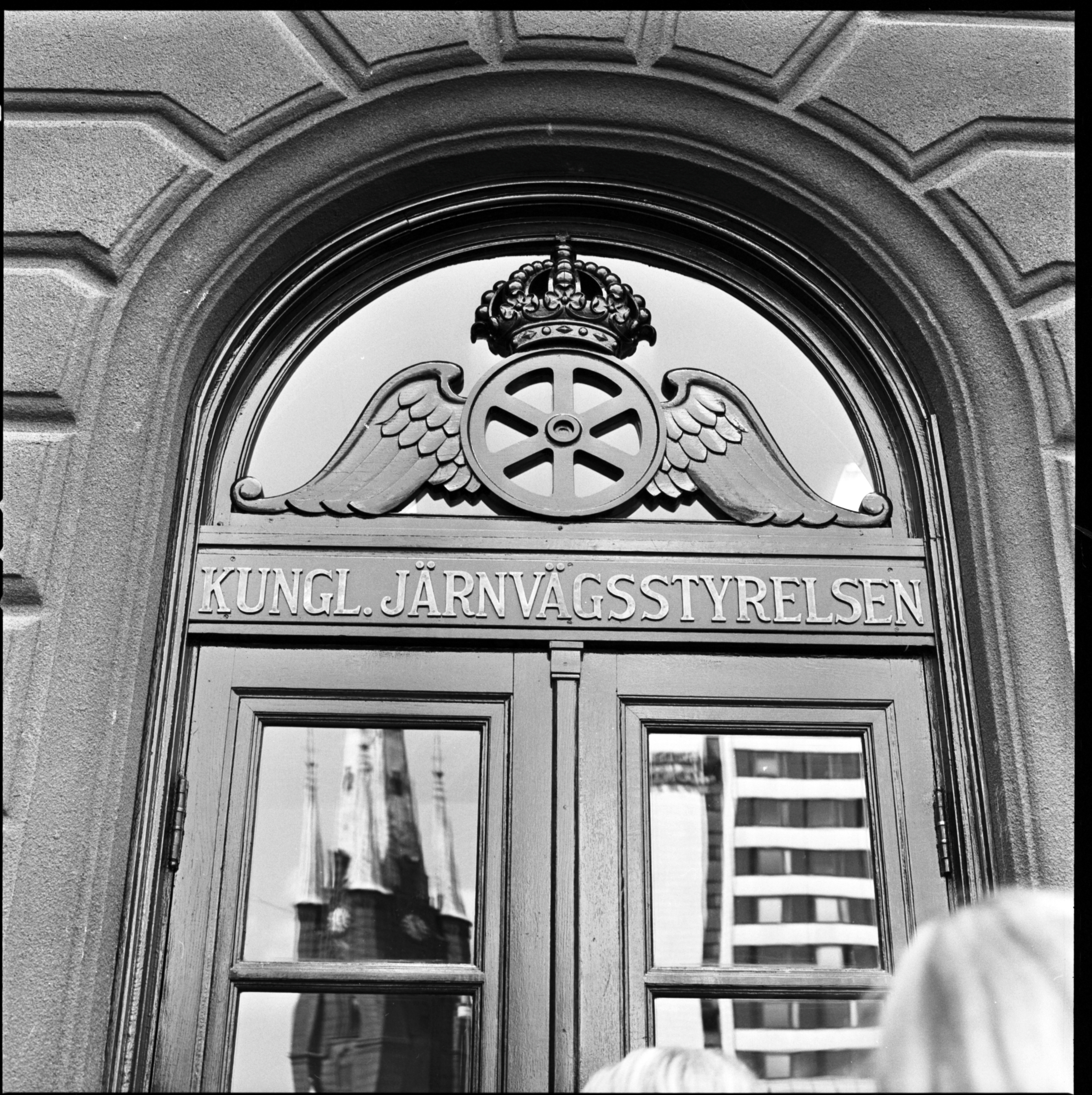 Huvudingång för dåvarande Kungliga Järnvägsstyrelsen vid Stockholm Centralstation. Rundad dörröppning med bevingat hjul ovanför dörren.