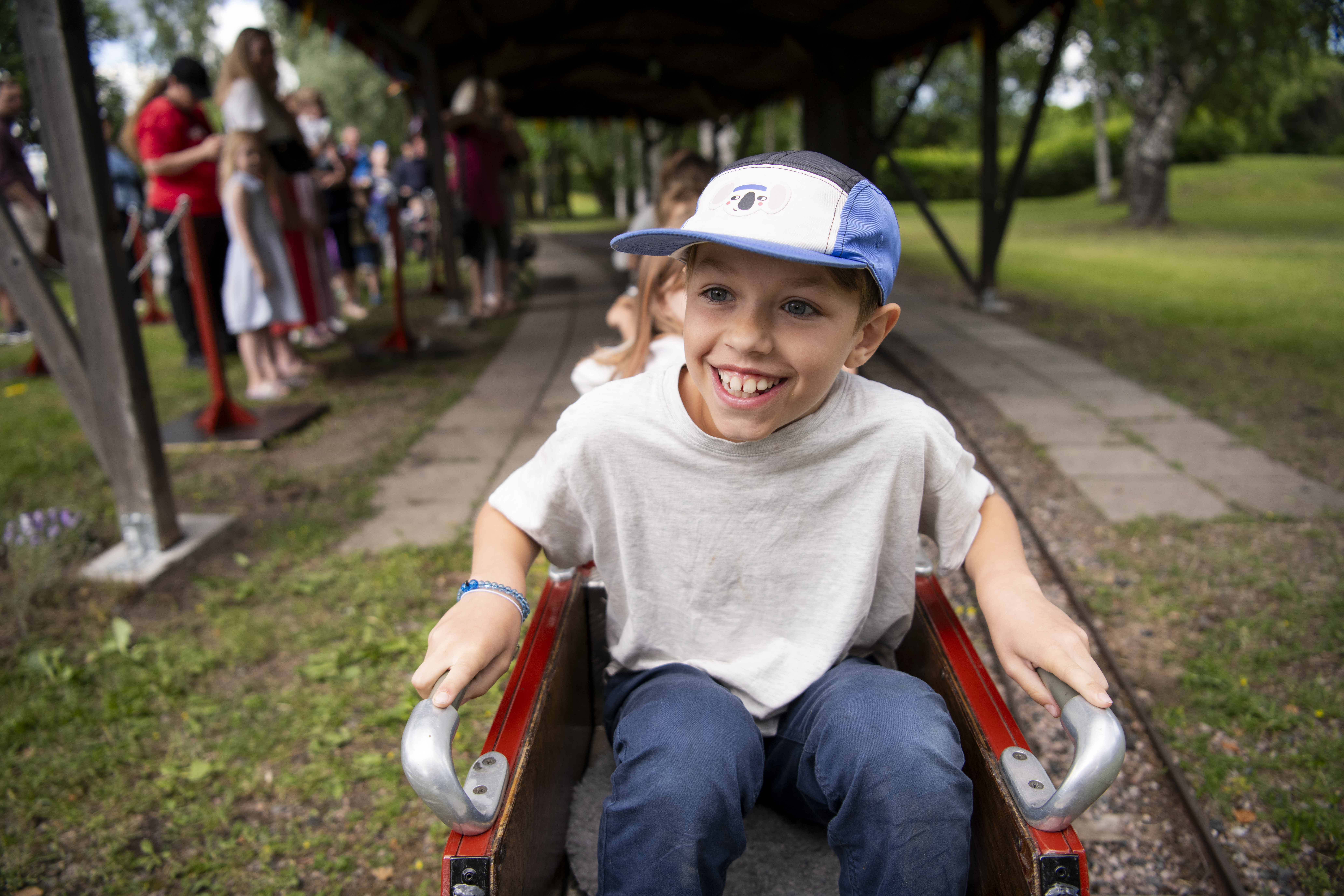 A happy boy is sitting in the mini train