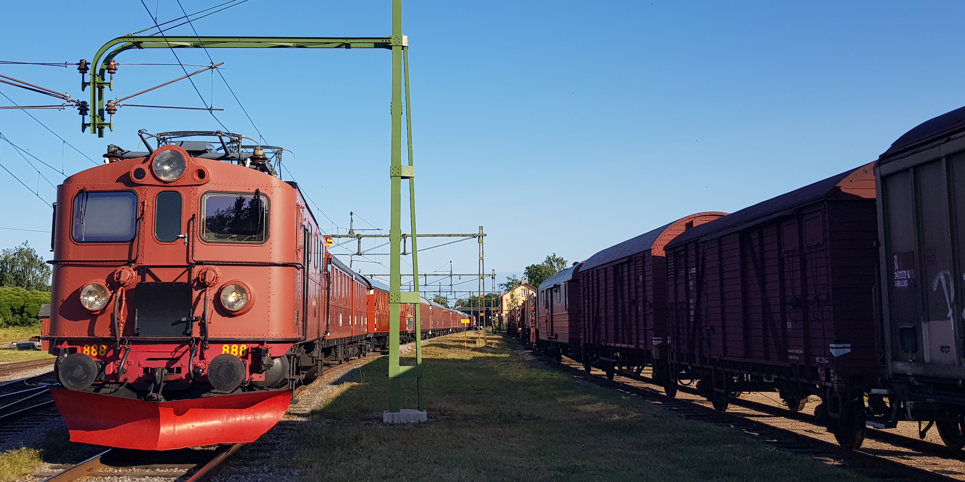 To the left, locomotive with many wagons. To the right, a long freight train.